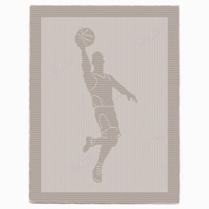 May include: A beige knitted blanket with a basketball player silhouette in a shooting pose. The design is in a lighter beige colour, with a darker beige border. The blanket has a textured appearance.