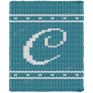 Op de afbeelding: Een rechthoekig gebreid stuk stof in de kleur blauwgroen met een grote witte letter C in het midden. Het ontwerp bevat twee horizontale witte strepen nabij de boven- en onderrand, elk geaccentueerd met een klein herhalend wit steekpatroon.