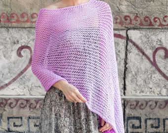 Può includere: Un poncho di maglia di colore lilla chiaro con una trama sciolta e aperta. Il poncho è drappeggiato sulle spalle di una persona ed è fatto di un filato morbido e leggero.