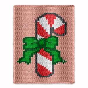 May include: A pixelated candy cane design on a pink knitted background. The candy cane features red and white stripes, with a green bow at the base. The design is reminiscent of a cross-stitch or needlepoint pattern, perfect for holiday decor.