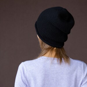 May include: A black knit beanie with a folded brim. The beanie is made of a soft, warm material and is perfect for keeping your head warm in the winter.