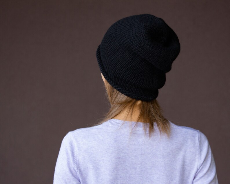 May include: A black knit beanie with a folded brim. The beanie is made of a soft, warm material and is perfect for keeping your head warm in the winter.