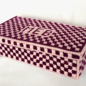 Può includere: Una scatola a scacchi rosa e viola con la parola "ICE" ricamata sulla parte superiore.