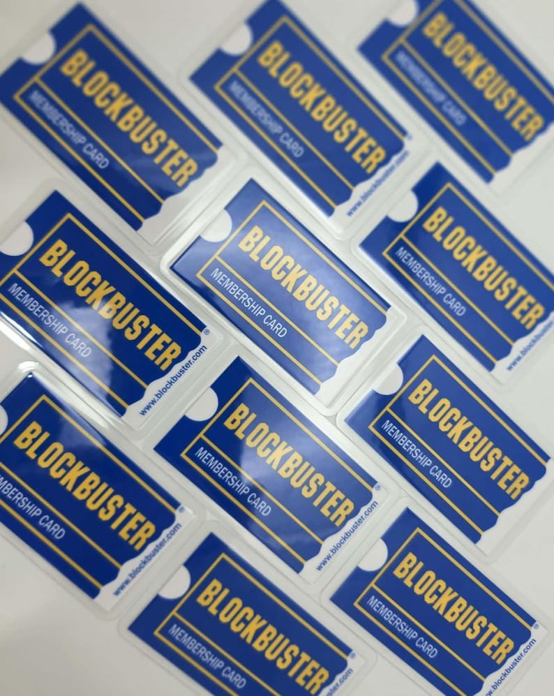 May include: A collection of rectangular blue and yellow Blockbuster membership cards arranged in a grid. Each card features the Blockbuster logo in yellow text, the words Membership Card, and the website address www.blockbuster.com.