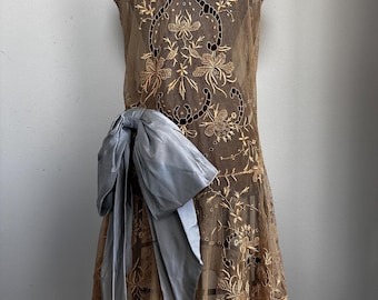 Vestido de renda de malha de gaze crua dourada estilo melindrosa dos anos 1920 com corte de renda Vestido de renda de malha de algodão com design floral e enorme laço de tafetá azul claro