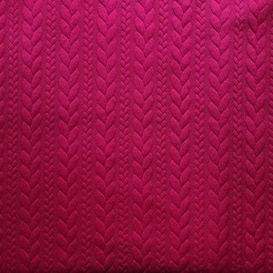Peut inclure: Gros plan sur un tissu magenta fonc&eacute;. Le tissu pr&eacute;sente un motif en relief r&eacute;p&eacute;t&eacute;, semblable &agrave; des tresses, cr&eacute;ant un effet tridimensionnel. La texture est riche et visuellement attrayante, avec une couleur magenta profonde.