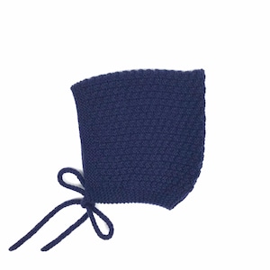 May include: A navy blue knitted baby bonnet with a tie at the bottom.