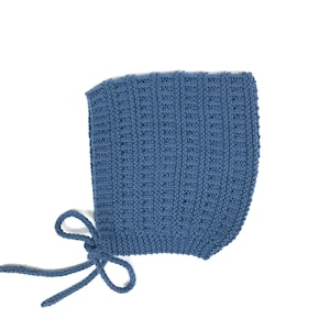 Può includere: Un berretto per neonato di lana blu con un nastro legato.