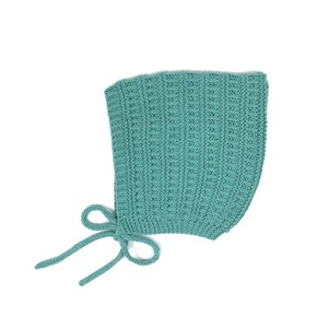 Può includere: Un berretto per neonato di colore azzurro chiaro in maglia con un fiocco sul retro.