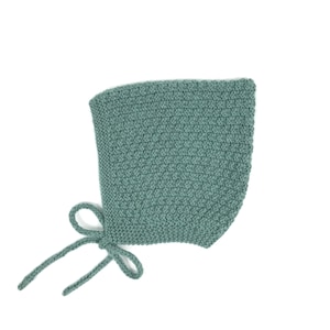 Può includere: Un berretto per neonato in morbido tessuto a maglia di colore blu-verde chiaro con un fiocco annodato in basso.