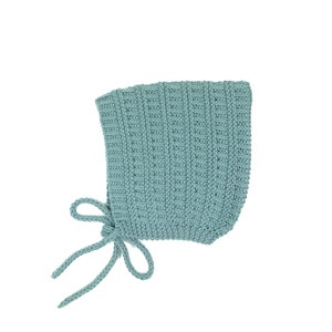 Pode incluir: Um gorro de bebé de malha azul claro com um laço na parte de trás.