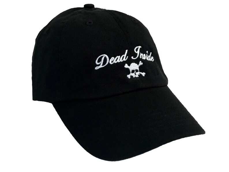 May include: Black baseball cap with a white embroidered skull and crossbones and the text "Dead Inside".
