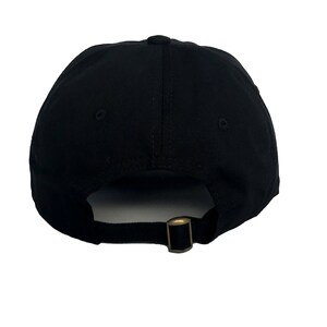 May include: A black baseball cap with a simple design. The cap has a curved brim and an adjustable strap at the back.