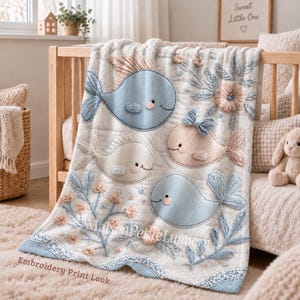 May include: A white quilted blanket featuring embroidered light blue and beige whales, floral accents, and the text "MaisonPetiteLumiere Embroidery Print Look". The design includes soft textures, pastel colors, and detailed stitching across the fabric surface.