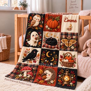 Autumn woodland baby blanket draped over a crib in a nursery, showing a patchwork look print with a sleeping owl, orange pumpkin and red-capped mushrooms in rust orange and cream