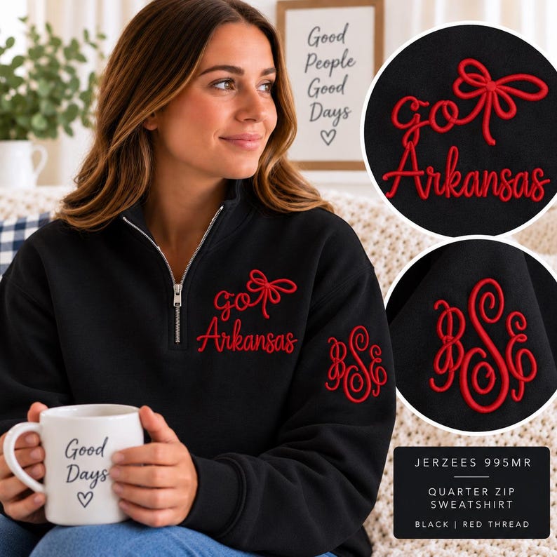 May include: A black quarter-zip sweatshirt featuring red embroidered text that reads "go Arkansas" with a bow graphic on the chest and a red embroidered monogram on the sleeve. The sweatshirt is labeled Jerzees 995MR and uses red thread.