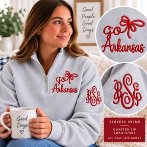 May include: An ash gray quarter-zip sweatshirt featuring red embroidery on the chest that reads "go Arkansas" with a bow icon. The left sleeve displays a red embroidered monogram with the letters "BSE" in a decorative script font.