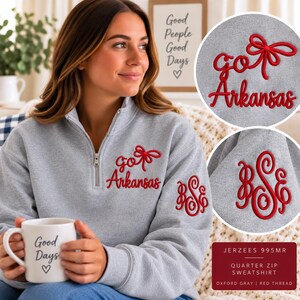 May include: A heather gray quarter-zip sweatshirt featuring red embroidery on the chest that reads "go Arkansas" with a bow icon. The left sleeve displays a red embroidered monogram with the letters "BSE" in a decorative script font.
