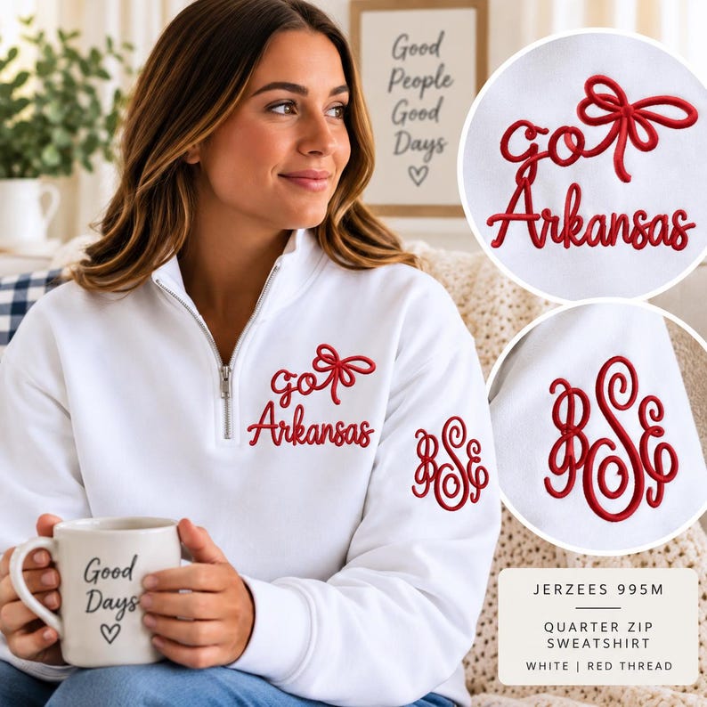May include: A white quarter-zip sweatshirt featuring red embroidery on the chest that reads "go Arkansas" with a bow icon. The left sleeve displays a red embroidered monogram with the letters "BSE". The fabric is a Jerzees 995M style.
