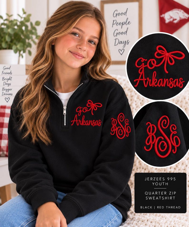 May include: A black quarter-zip sweatshirt featuring red embroidery. The chest displays the text "go Arkansas" with a bow graphic, while the sleeve features a red monogram with the letters "BSE". The garment is labeled as Jerzees 995 Youth.