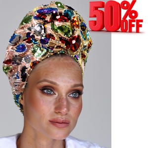 Peut inclure: Un couvre-chef beige orné de sequins et de perles colorés. Le couvre-chef est orné de sequins de différentes formes et tailles dans des tons de bleu, vert, rouge et or. Le texte "50% OFF" est en rouge.