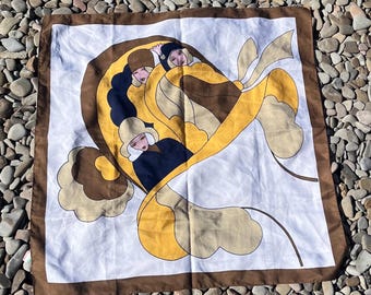 May include: A square scarf featuring a white background with a brown border. The central graphic depicts stylized figures in yellow, brown, and black tones, arranged within a curved, ribbon-like frame that flows across the fabric surface.