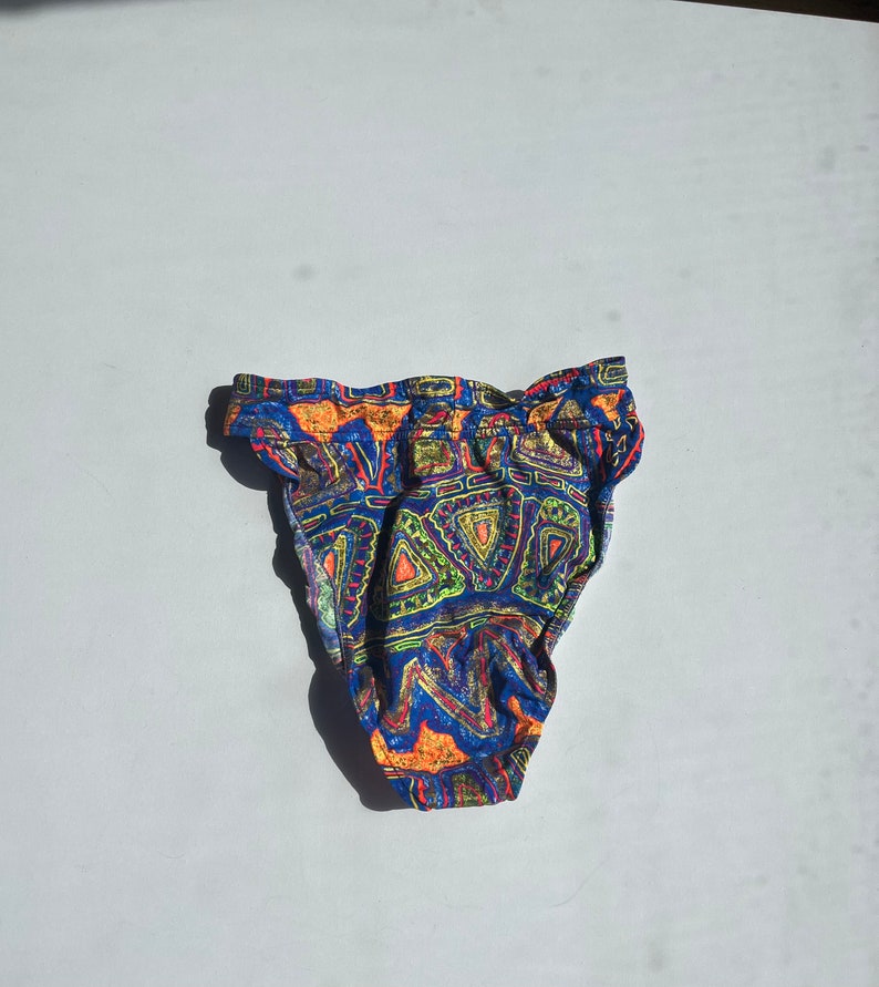 May include: Blue, orange, green, and yellow patterned bikini bottom with a high waist.