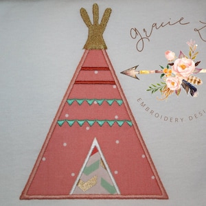 Può includere: Disegno ricamato di un teepee rosa e bianco con una cima dorata, circondato da punti bianchi. Il design include un motivo a chevron verde e oro all'interno del teepee. Il testo "Gracie Lou Embroidery Design" è visibile nell'angolo in alto a destra dell'immagine.