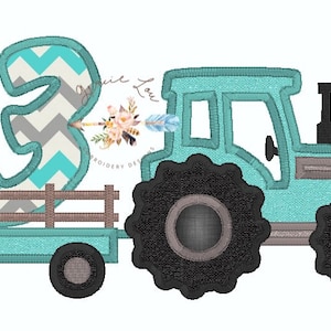 Op de afbeelding: Een turquoise blauwe tractor met een grijs en turquoise nummer drie achterop. Het nummer drie heeft een chevron-patroon. De tractor heeft een bruine houten wagen achterop.
