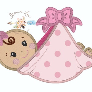 Puede incluir: Diseño bordado de una niña bebé envuelta en una manta rosa con lunares y un lazo rosa en la parte superior. El texto "Jennie Lou" está por encima del bebé.