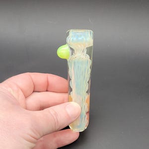 May include: A white ceramic mug with a black handle and the text "But First, Coffee" in a black, handwritten-style font. The mug is on a white surface.