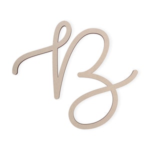 May include: A wooden cutout of the letter "B" in a cursive script style. The letter is painted in a light brown color.