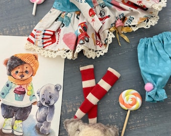 May include: A handmade teddy bear wearing a red and white dress with a white lace trim. The bear is sitting on a wooden surface with a blue and white striped fabric and a red and white striped fabric. There are two lollipops, one pink and one yellow, and a blue and white fabric with white polka dots.