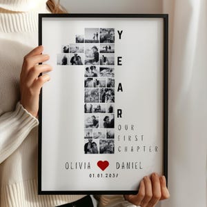 May include: A framed black and white photo collage. The collage is in the shape of the number one, composed of multiple small photos. Text includes "YEAR", "OUR FIRST CHAPTER", names "Olivia" and "Daniel", a heart symbol, and the date "01.01.2037".