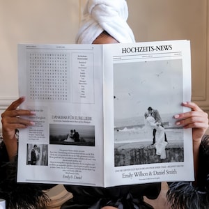 May include: A person holding a newspaper titled "HOCHZEITS-NEWS" with wedding content. The newspaper features a word search, wedding photos, and the names "Emily Willson & Daniel Smith". The person is wearing a white towel and a black robe.