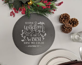 Puede incluir: Un posavasos redondo de pizarra gris con el texto "Getting wisdom is the wisest thing you can do - Proverbs 4:7" en letras blancas.