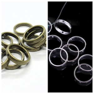 May include: Two sets of metal jump rings, one set is gold and the other is silver. Both sets have small decorative dots on the rings.