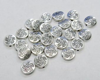 May include: A collection of silver-toned metal beads with a geometric design. The beads are round and have a raised design in the center.
