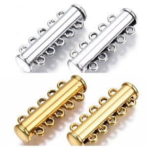 May include: Four-strand necklace clasps in silver and gold tones. Each clasp has a cylindrical body with three sets of loops for attaching multiple strands. The clasps are designed for jewelry making and crafting.