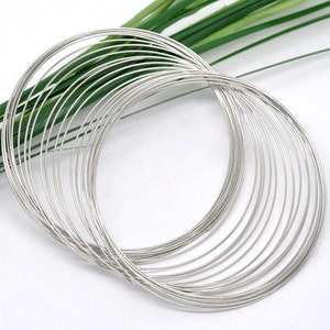 May include: A stack of silver wire rings, perfect for jewelry making or crafting projects.