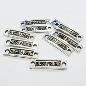 May include: Ten silver-toned metal charms with the words "Best Friend" engraved on them. The charms have two holes for attaching to jewelry or other crafts.