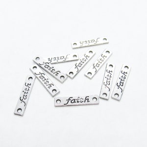 May include: Silver metal charms with the word "faith" engraved on them. The charms have two holes for attaching to jewelry or other crafts.