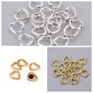 May include: A collection of silver and gold heart-shaped jump rings. The rings are open and have a slightly textured surface. They are ideal for jewellery making and crafting.