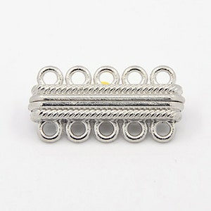 May include: Silver-toned metal clasp with six loops for attaching jewelry chains or cords. The clasp has a rope-like design.