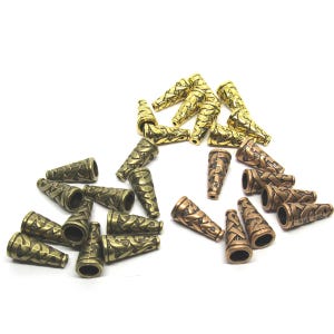 May include: A selection of cone-shaped metal beads in gold, bronze, and antique brass finishes. Each bead has an embossed pattern. The beads are scattered on a white surface, ideal for jewellery making or craft projects. Measurements are in centimetres.