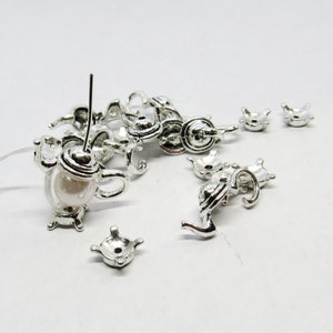 May include: Silver teapot charms with a pearl accent. The charms are perfect for jewelry making or scrapbooking.
