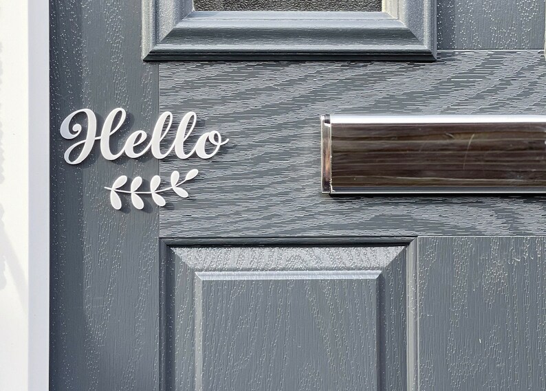 May include: A grey front door with a white "Hello" sign and a silver letterbox.