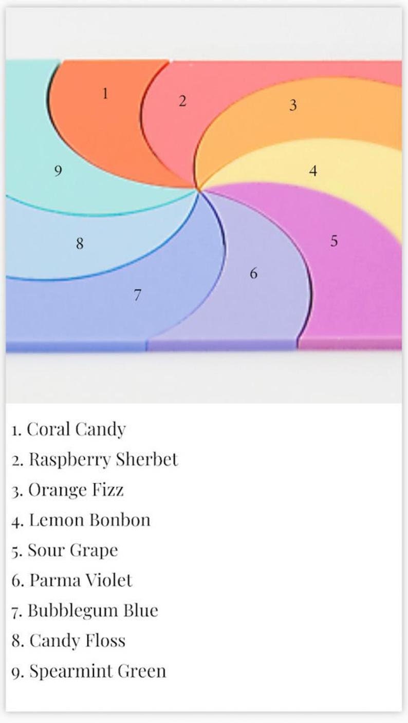 May include: A colourful spiral design with nine sections, each labelled with a number and a corresponding flavour name. The flavours are: Coral Candy, Raspberry Sherbet, Orange Fizz, Lemon Bonbon, Sour Grape, Parma Violet, Bubblegum Blue, Candy Floss, and Spearmint Green.