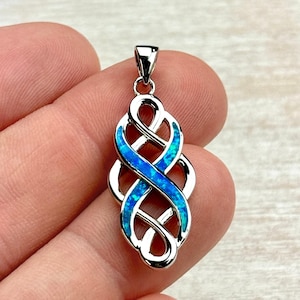 May include: A silver-colored pendant with a Celtic knot design. The pendant features a blue opal inlay that weaves through the knot. The pendant is approximately 1.5 inches long and has a small loop at the top for a chain.