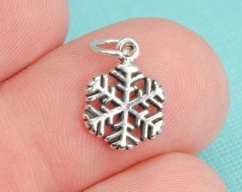 Könnte beinhalten: Silberner Schneeflocken-Anhänger mit einer Öse zum Anbringen an Schmuck oder andere Bastelarbeiten.